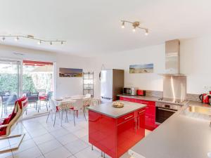 アモツにあるHoliday Home Mendi Bixta by Interhomeのキッチン(赤いキャビネット、テーブル、椅子付)