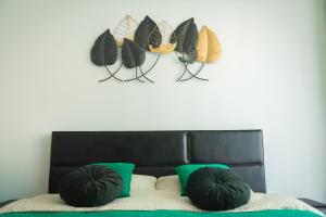 ein Schlafzimmer mit einem schwarzen Kopfteil mit Schmetterlingen an der Wand in der Unterkunft CITY VIBE STUDIO in Braşov