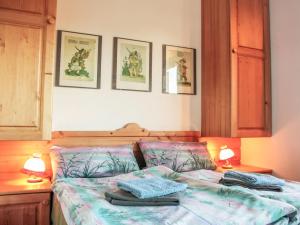 a bedroom with a bed with two lamps and pictures on the wall at Holiday Home Berghaus Weitblick by Interhome in Ramsau am Dachstein