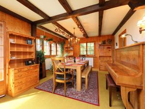 a dining room with a table and a piano at Chalet L'Oiselet by Interhome in Villars-sur-Ollon