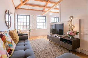 sala de estar con sofá y TV en Newly Renovated Cozy Central Loft w/ AC by LovelyStay, en Oporto