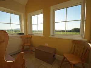 LlangwnadlにあるHoliday Home Brandy by Interhomeの椅子2脚と窓2つが備わる客室です。