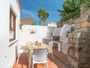 a patio with a table and chairs on a wall at Holiday Home Sibilla by Interhome in Pedrumalu