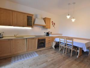 kuchnia z drewnianymi szafkami, stołem i krzesłami w obiekcie Apartment Elettra-7 by Interhome w mieście Crone