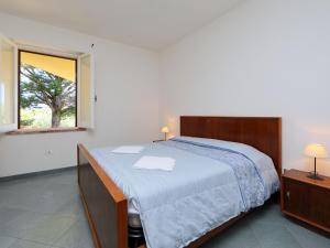 sypialnia z dużym łóżkiem i oknem w obiekcie Apartment Ananas 4 D by Interhome w mieście Valledoria +20 zdjęć