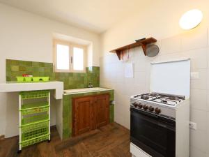 ヴァッレドーリアにあるApartment Ananas 2 A by Interhomeの緑と白のタイルを用いたキッチン(コンロ付)
