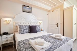 a white bedroom with a large bed with two towels on it at Mataraci Konak in Istanbul