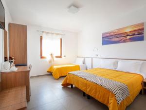 2 camas en una habitación con sábanas amarillas en Navicri B&B, en Vieste