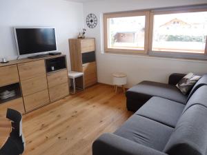 a living room with a couch and a flat screen tv at Apartment Jardins d'Helene by Interhome in Ovronnaz