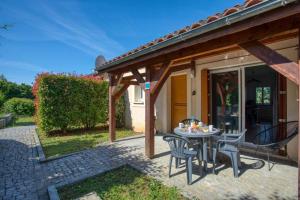 un patio con mesa y sillas frente a una casa en SARLAT - 24 - L'appartement d'Euphé avec piscine en Sarlat-la-Canéda