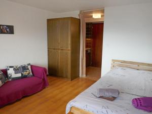 ein Schlafzimmer mit einem Bett und einem Sofa in der Unterkunft Apartment Anémone 20 by Interhome in Nendaz