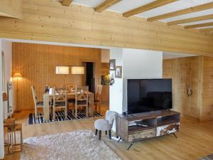 a living room with a table and a large television at Apartment Regina B9 by Interhome in Villars-sur-Ollon