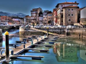 a row of boats in a river in a city at Apartamento Marina Llanes III in Llanes