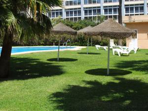 una piscina con sedie e ombrelloni in erba di Apartment Dali by Interhome a Torremolinos
