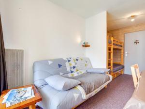 Apartment Ski Soleil 1 by Interhome في ليه مينوير: غرفة معيشة مع أريكة وسرير بطابقين