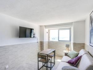 un salon avec un canapé et une télévision sur un mur dans l'établissement Studio Les Sables d'Aiguebelle-1 by Interhome, à Aigue-Belle