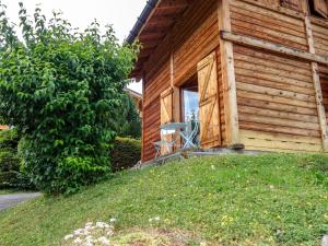 ein Holzhaus mit einem Stuhl draußen in der Unterkunft Holiday Home Les Farfadets by Interhome in Saint-Gervais-les-Bains