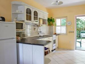 バラトンマーリアフュルドゥーにあるHoliday Home Welle by Interhomeのキッチン(白いキャビネット、白い冷蔵庫付)