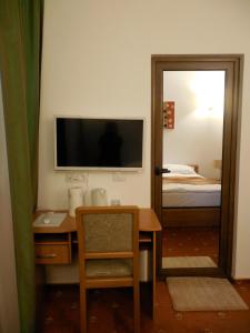 a room with a desk with a television and a mirror at Villa AnnaLia - Rooms to Rent in Bacău