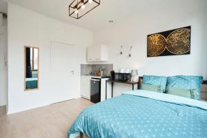 um quarto com uma cama azul e uma cozinha em LocationsTourcoing - Le Nature em Tourcoing