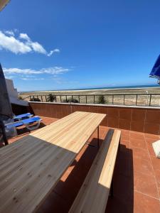 a wooden bench sitting on top of a building next to the beach at Panorama Sun Figueira - 1er ligne Mer in Figueira da Foz