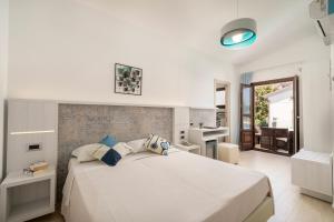 a bedroom with a large white bed and a bathroom at Hotel Ristorante La Conchiglia in Cala Gonone