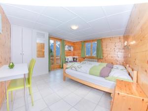 グレヘンにあるApartment Bergfink Obergeschoss-6 by Interhomeのベッドとテーブルと椅子のある寝室