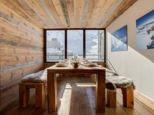 ein Esszimmer mit einem Tisch und einem Fenster in der Unterkunft Apartment Les Grandes Platières-23 by Interhome in Tignes