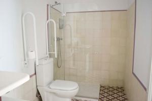 a white toilet sitting next to a bath tub in a bathroom at Casas y Patios de Sevilla in Seville
