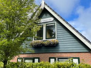 een huis met twee ramen met bloembakken erop bij Holiday Home Villa Favorita by Interhome in Zonnemaire