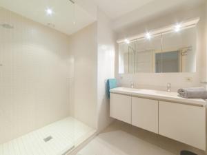 ein weißes Badezimmer mit einem Waschbecken und einem Spiegel in der Unterkunft Apartment Seaside 4-02 by Interhome in Bredene