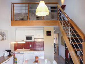 eine Küche mit einer Treppe, die zu einem Loft führt in der Unterkunft Holiday Home Hameau des Tamarins-1 by Interhome in Le Barcarès