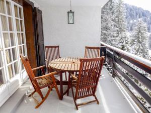 a table and two chairs on a balcony with snow covered trees at Apartment Savoie 1 by Interhome in Villars-sur-Ollon
