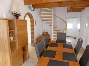 una sala da pranzo con tavolo, sedie e scala di Holiday Home Reuse by Interhome a Norddeich