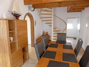 un comedor con mesa y sillas y una escalera en Holiday Home Reuse by Interhome en Norddeich