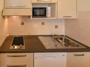 a kitchen with a sink and a microwave at Apartment Kristall by Interhome in Mezzana