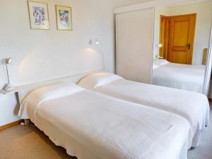 a hotel room with two beds and a mirror at Apartment Le Miclivier B1 by Interhome in Villars-sur-Ollon