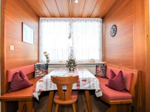 una sala da pranzo con tavolo e sedie rosse di Apartment Alpenland-21 by Interhome a Seefeld in Tirol