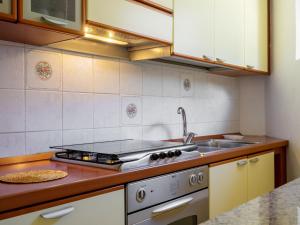 a kitchen with a stove and a sink at Holiday Home La mia Casetta by Interhome in Porto Valtravaglia +18 photos
