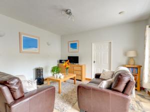 a living room with two couches and a tv at Holiday Home Pebbles- Marazion by Interhome in Marazion