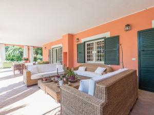 ein Wohnzimmer mit Korbmöbeln und orangefarbenen Wänden in der Unterkunft Villa Giulia by Interhome in La Massimina-Casal Lumbroso