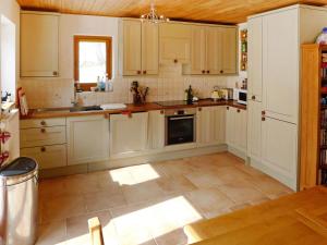 a kitchen with white cabinets and a tile floor at Holiday Home Chalet Eden by Interhome in Blatten im Lötschental