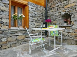 a table and chairs in front of a stone wall at Holiday Home Rustico Nurell by Interhome in Madra