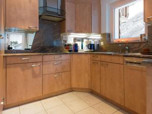 a kitchen with wooden cabinets and a window at Chalet Haus Piccolo by Interhome in Saas-Grund