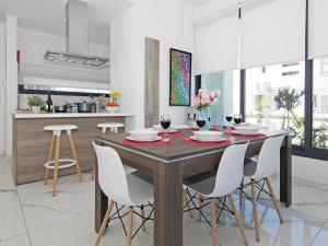 - une cuisine avec une table en bois et des chaises blanches dans l'établissement Villa melody by Interhome, à Protaras