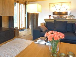 a living room with a blue couch and a vase of flowers at Chalet Chalet Astoria by Interhome in Crans-Montana +68 photos