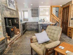 a living room with a couch and a fireplace at Ha'penny Cottage in Holmfirth