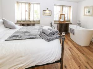 a bedroom with a large bed and a bath tub at Ha'penny Cottage in Holmfirth
