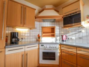 kuchnia z drewnianymi szafkami i białą płytą kuchenną w obiekcie Holiday Home Ennstal by Interhome w mieście Radstadt
