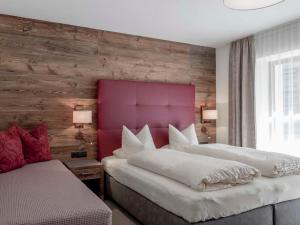 a bedroom with two beds and a red headboard at Apartment The PEAK-3 by Interhome in Sölden